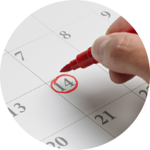 Krupan plan ruke koja crvenom olovkom zaokružuje datum na kalendaru